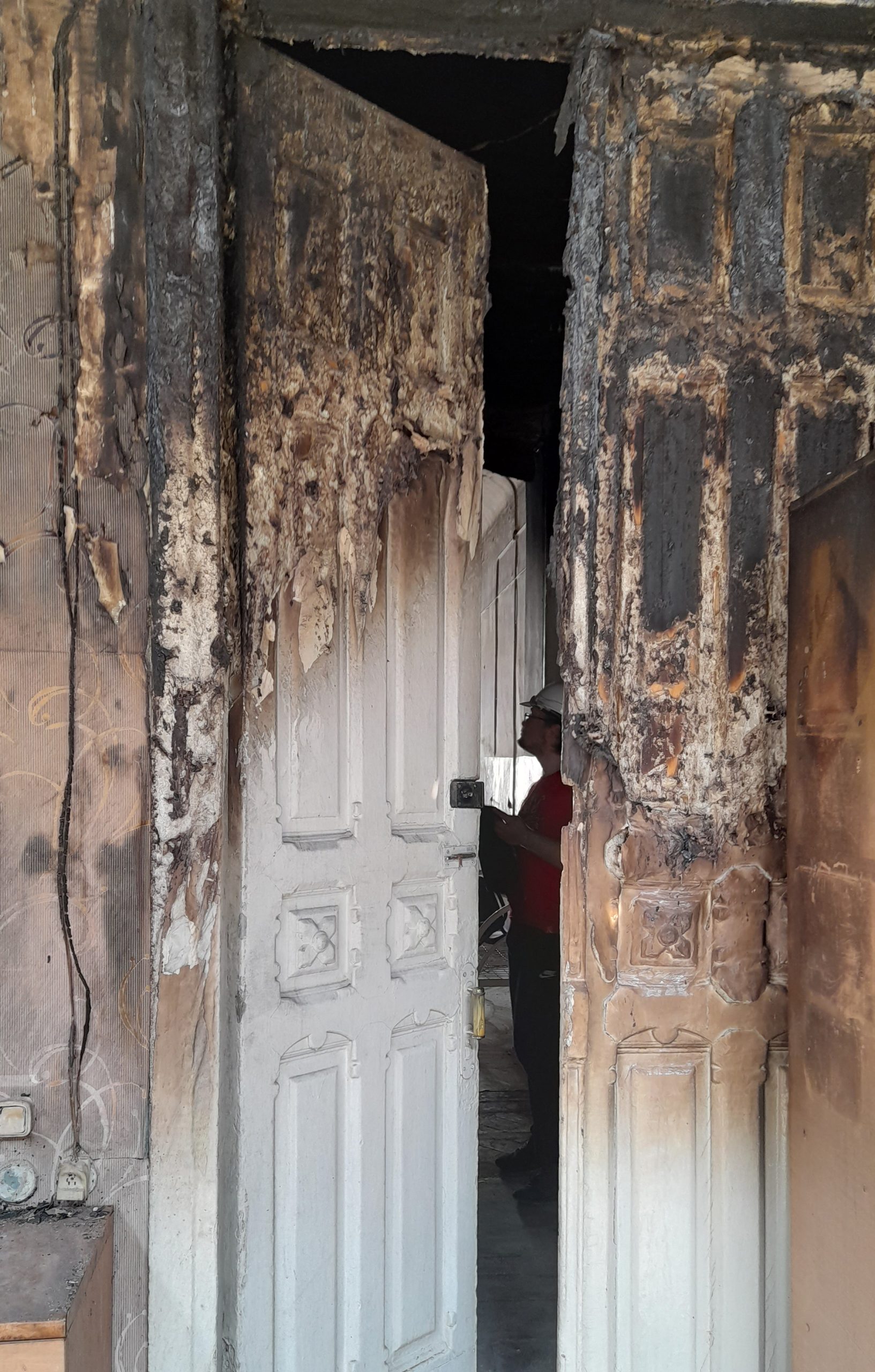 A burnt door in a historical 19 century mansion. A member of a our team is behind the door. 