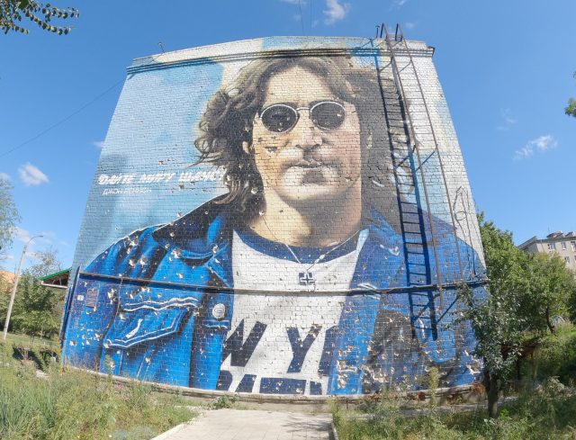A mural cut by shrapnel on the apartment building on the central John Lennon Square in Izium