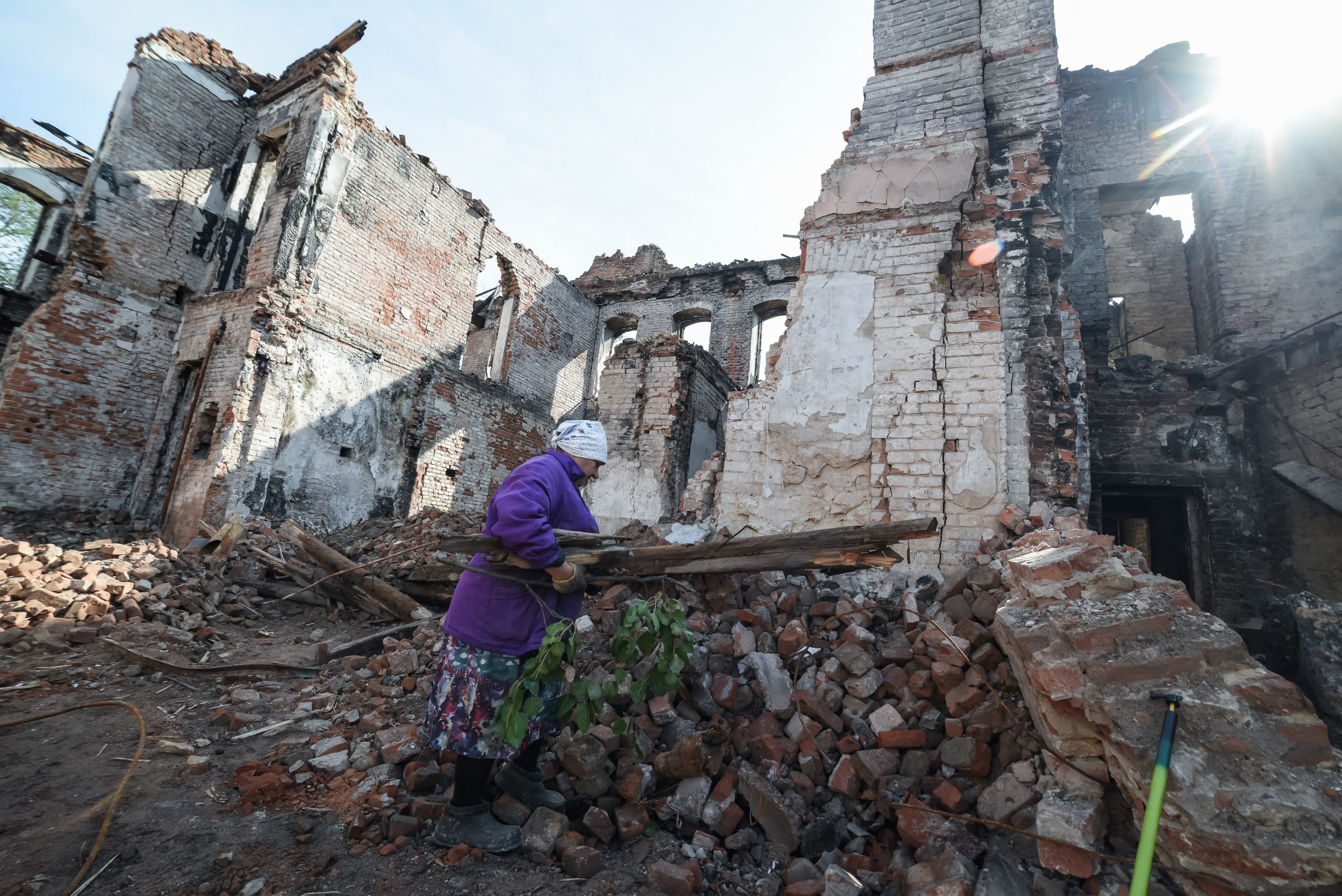 Izyum, Kharkiv region. Woman is collecting wood from the rubbles of a school for cooking on the fire outdoors. As of October 1, 2022 there was no gas, no electricity, no water. Photo was taken on Oct 01, 2022 by Yevhen Tytarenko.