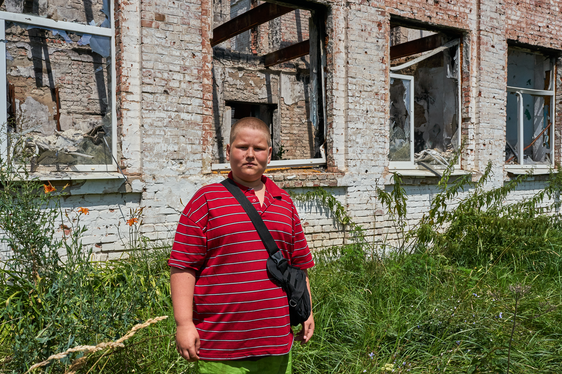 Seryozha poses for a photo in front of an elementary school in the village of Staryi Saltiv in Kharkiv region. The village was captured immediately after the start of the Russian full-scale invasion in February 2022 and was liberated in May 2022. "My family stayed during the occupation, but we were evacuated by the Red Cross a couple days after our village was liberated. When Russian soldiers retreated, when they left the village, they started to shell us. Therefore, we were evacuated to Dnipro". Seryozha used to go to this elementary school which has only four grades. He then continued to study in Lyceum located next to the elementary. "My family came back to our village two months ago". Seryozha likes to play soccer. He thinks school will continue only on-line. He does not have a laptop and he uses his Wi-Fi on his phone. 